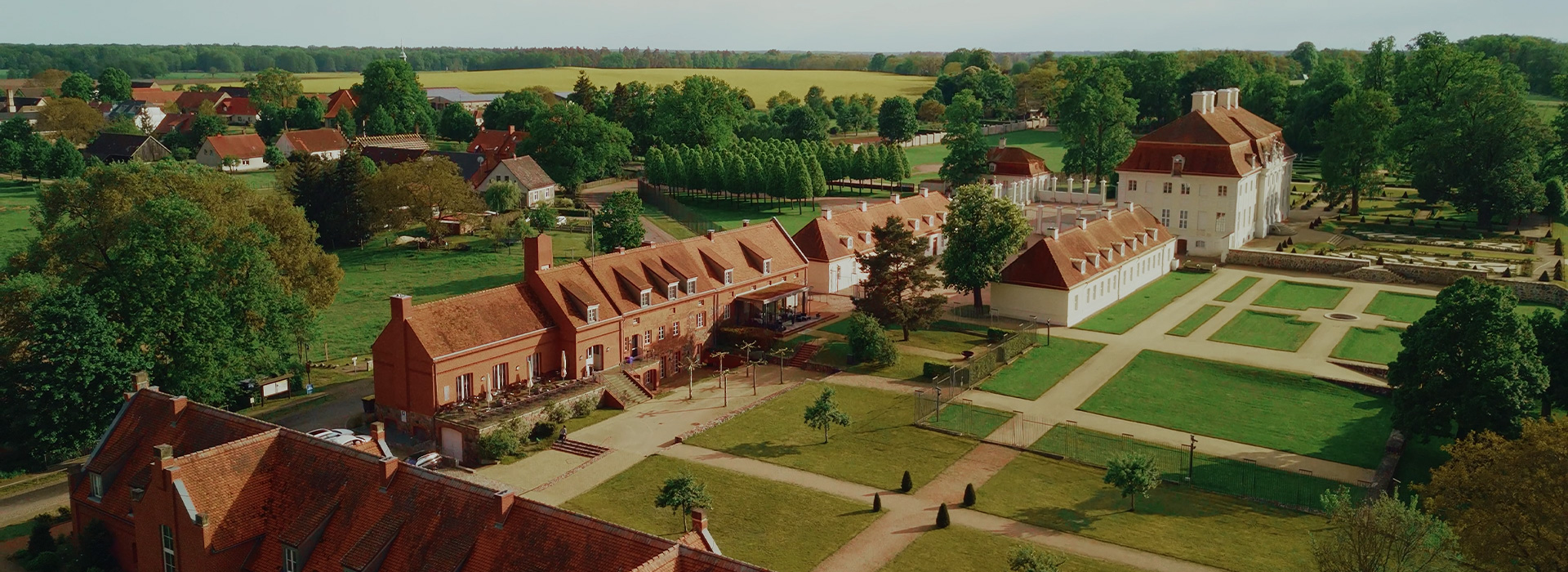 Luftaufnahme des Schlosswirts Meseberg neben Schloss Meseberg und seiner Gartenanlage